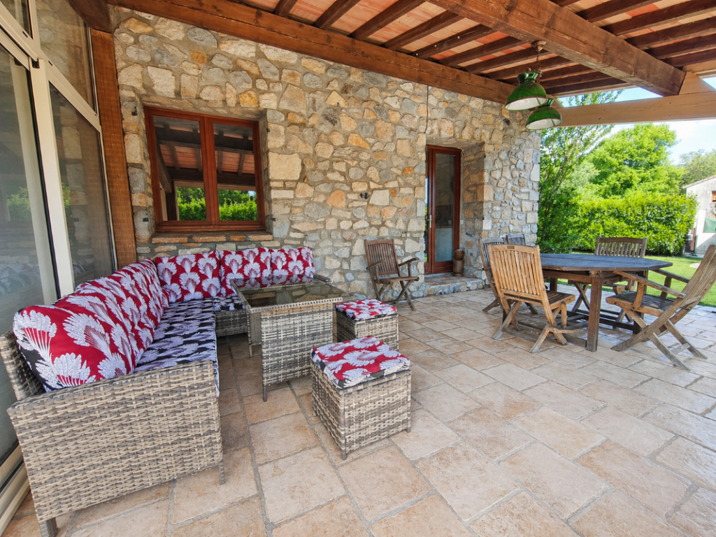 terrasse de l'appartement le thibélie chez les gîtes de chrysmo à Vallon Pint d'Arc en Ardèche avec salon de jardin et table à manger sous abri